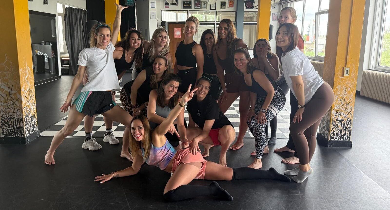 Vriendinnengroep die lachend leren twerken in een workshop.