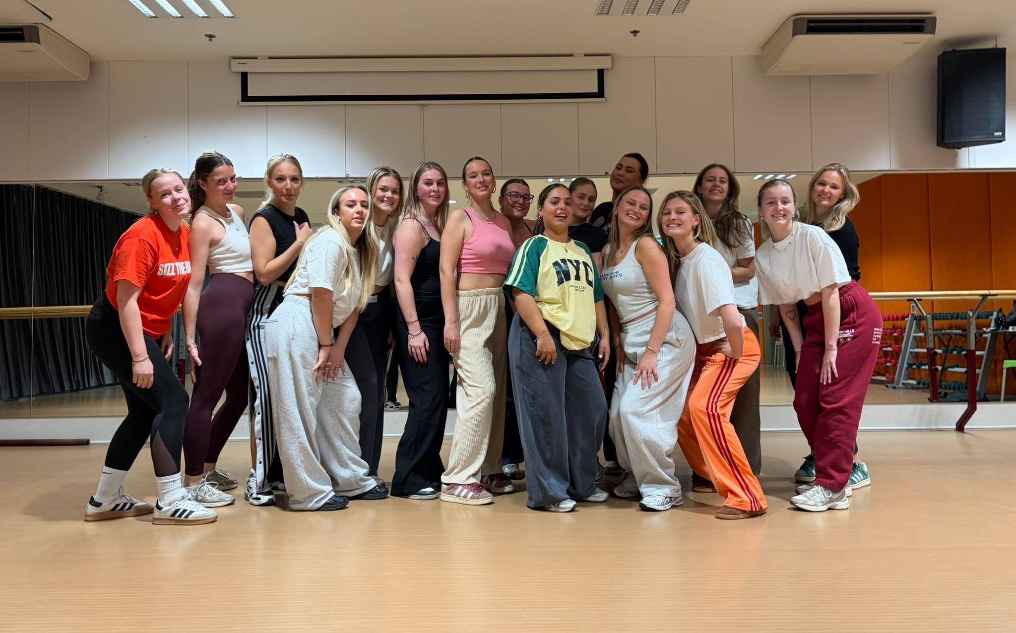 Enthousiaste vriendinnengroep tijdens een twerkworkshop op locatie