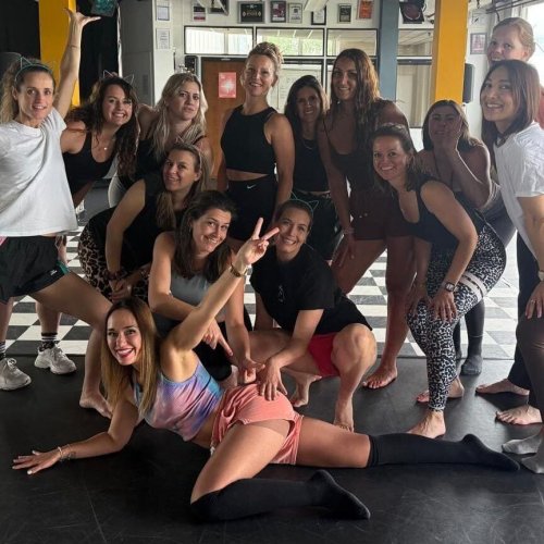 Vriendinnengroep die lachend leren twerken in een workshop.