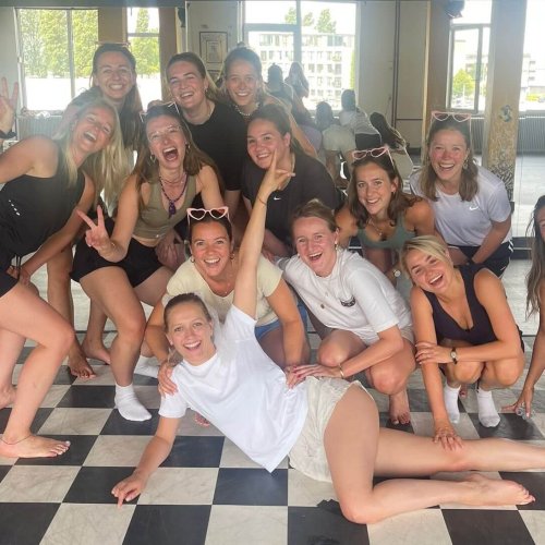 Een gezellige groep vriendinnen die in een workshop leren twerken en de basisbewegingen onder de knie krijgen.